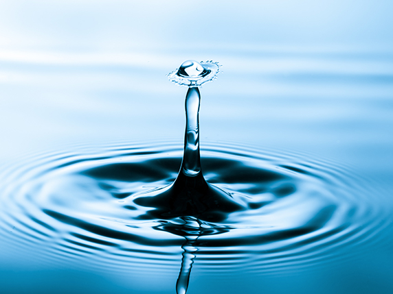 Wohltuende Wirkung der Emsan Mineralsalze Bild zeigt einen Tropfen, der auf eine Wasseroberfläche trifft.