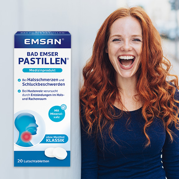 Eine Frau lacht herzlich. Daneben die Packung der Emsan Bad Emser Pastillen Klassik