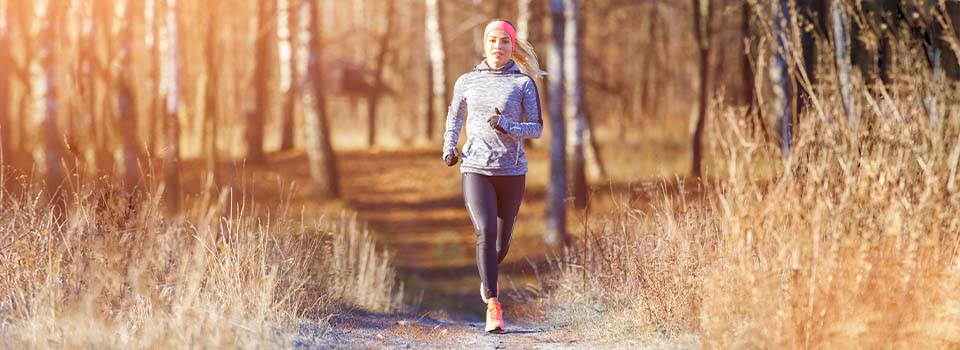 Frische Luft hält die Mund- und Nasenschleimhaut feucht. Eine Frau joggt im Herbst.