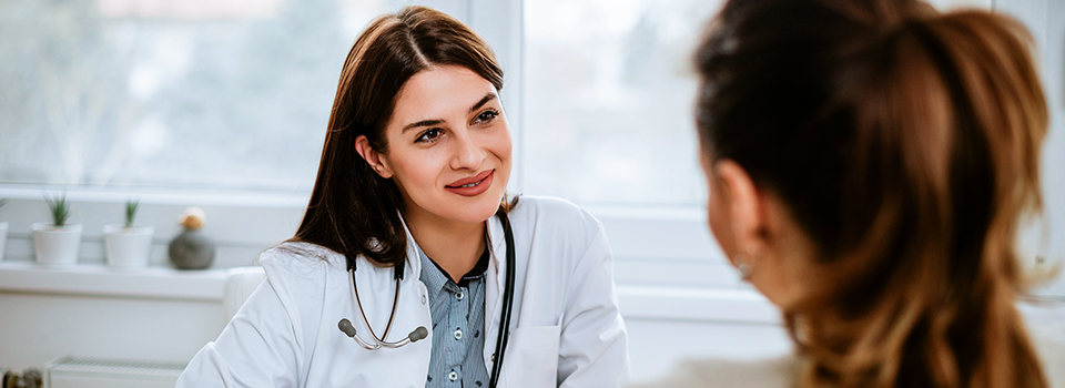Das Vorgespräch liefert Ärzten und Ärztinnen oft erste Hinweise auf mögliche Ursachen des Hustens. Eine Ärztin führt mit einer Patientin ein Anamnesegespräch.