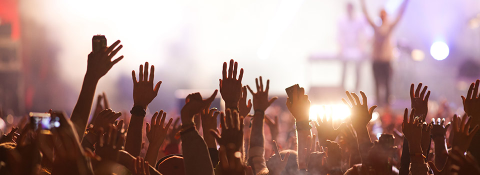 Das A und O bei Heiserkeit: die Stimme schonen Feiernde auf einem Konzert vor der Bühne